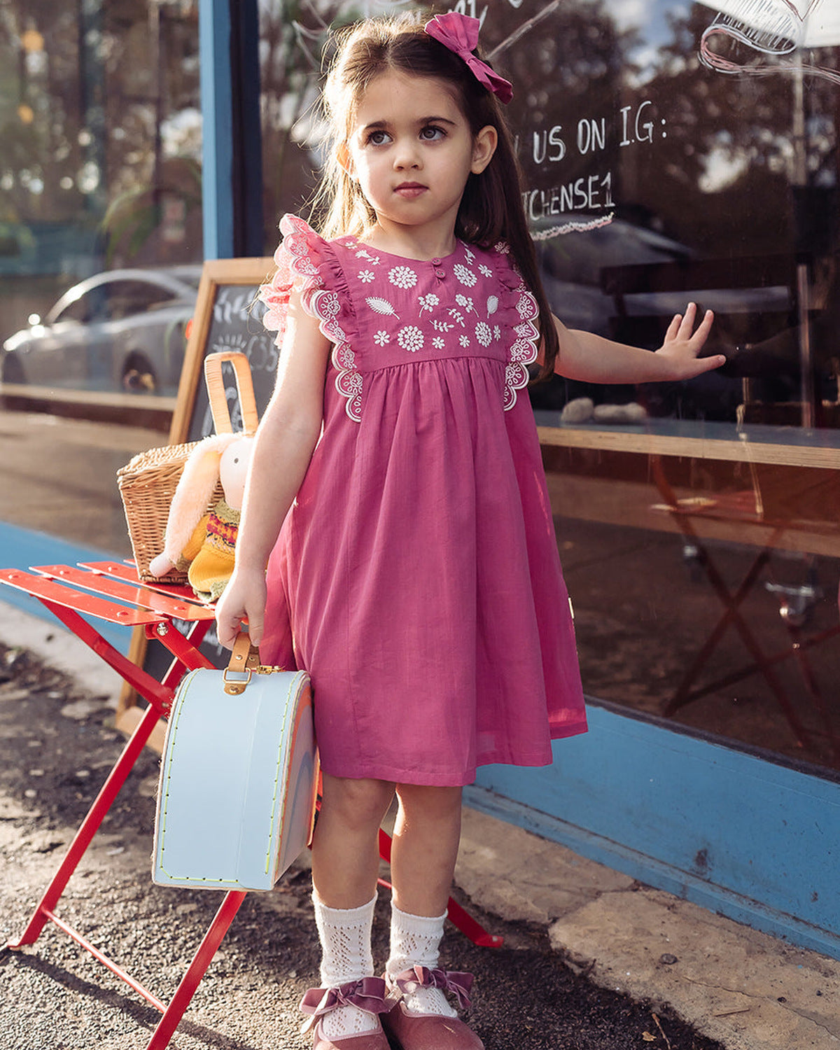 Happyology girl with a suitcase outside the studio
